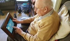 oudere man die via tablet contact legt met familie
